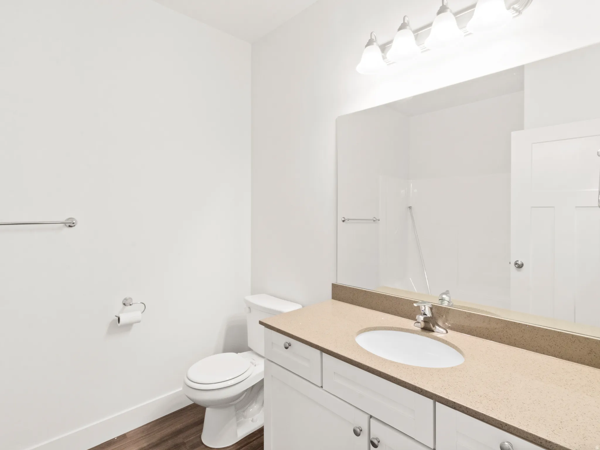 Full bathroom featuring vanity, dark wood-type flooring, and a shower