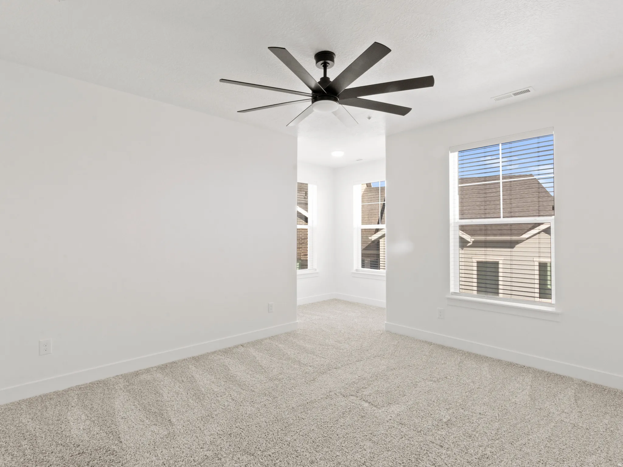Unfurnished room featuring carpet and ceiling fan