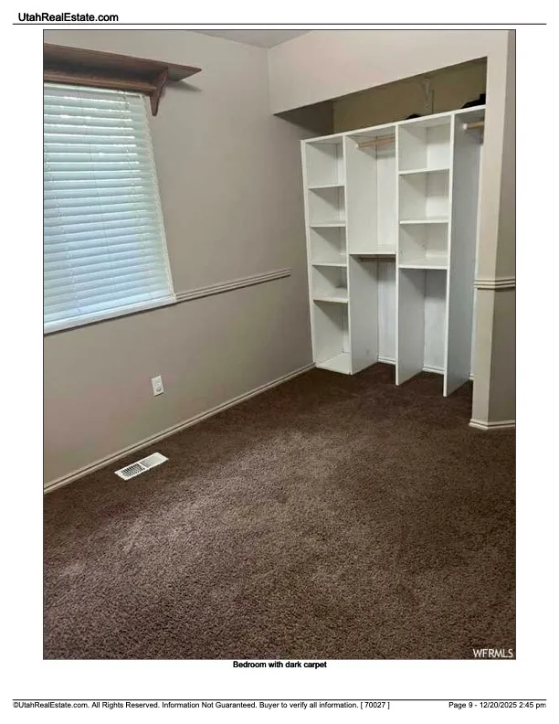 Unfurnished bedroom featuring dark carpet and baseboards