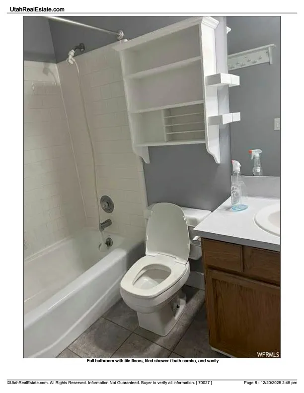 Bathroom with vanity, tub / shower combination, and light tile patterned flooring