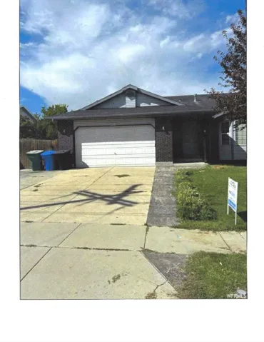 Ranch-style home featuring concrete driveway, a garage, and a front lawn