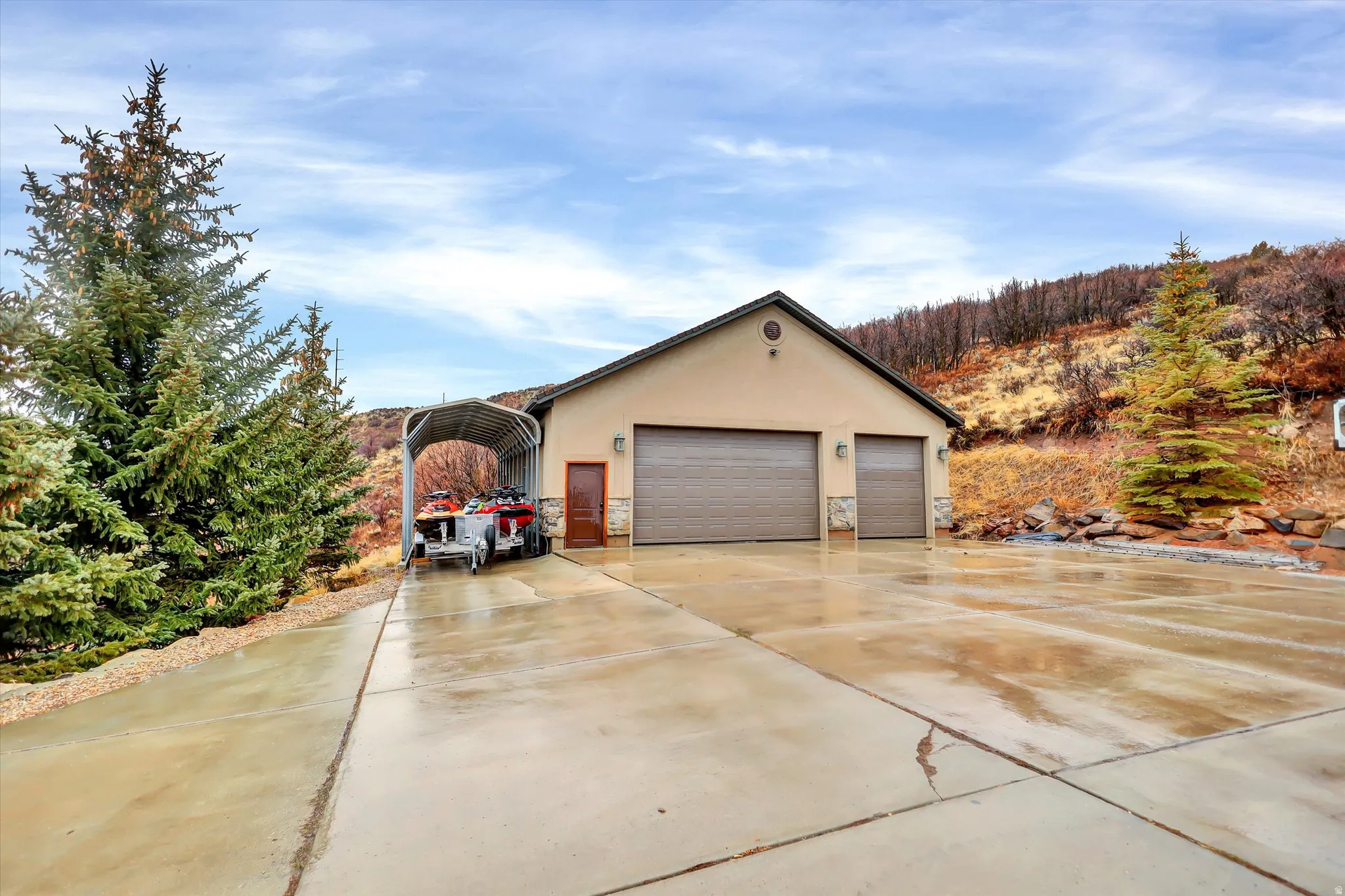 Detached garage with a carport and driveway