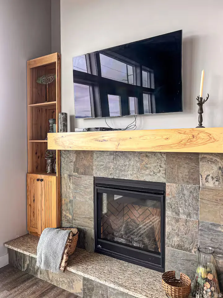 GUEST HOUSE Detailed view of a glass covered fireplace and wood finished floors