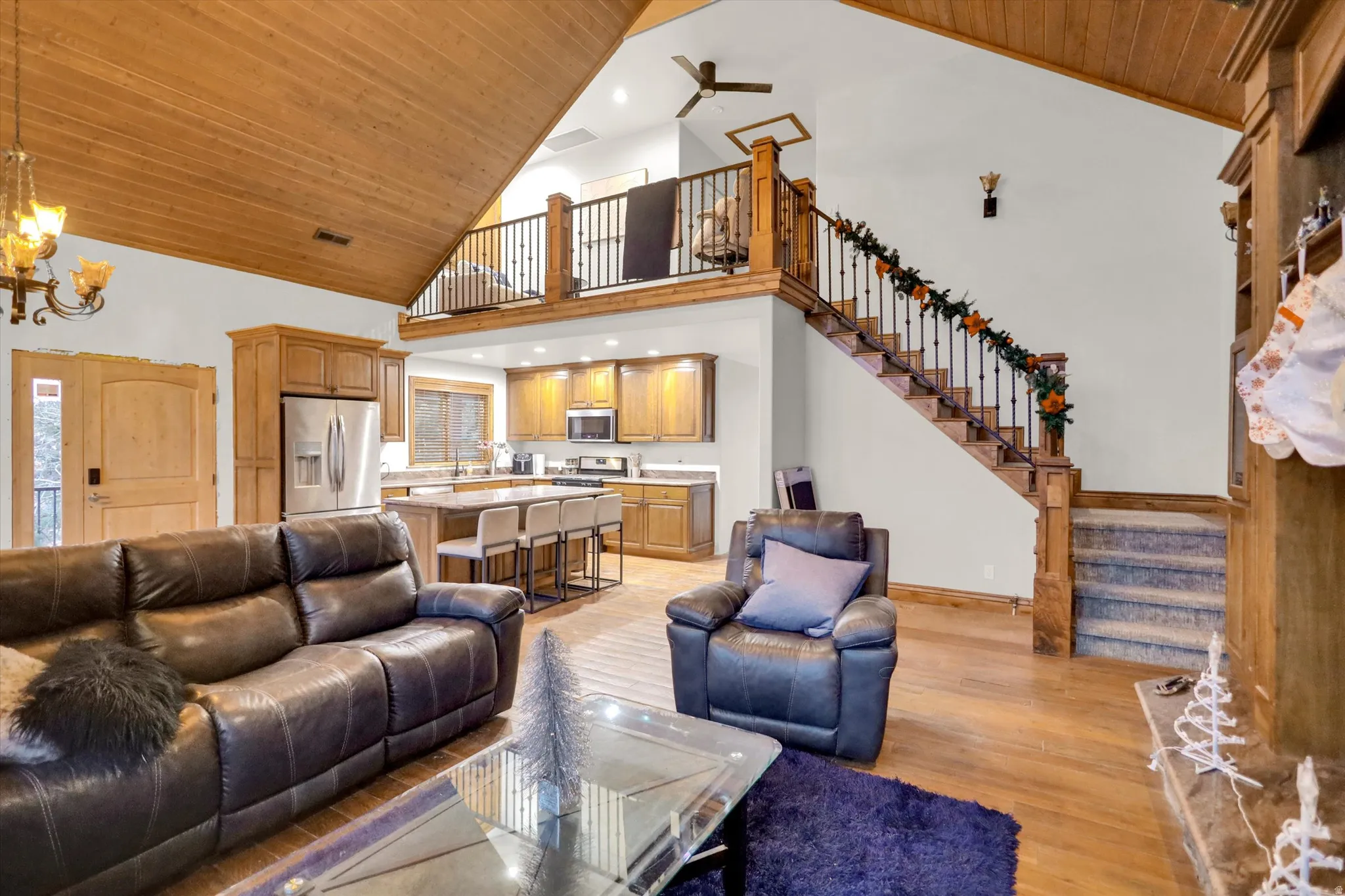 Living area featuring wood ceiling, high vaulted ceiling, light wood-style flooring, stairway, and recessed lighting