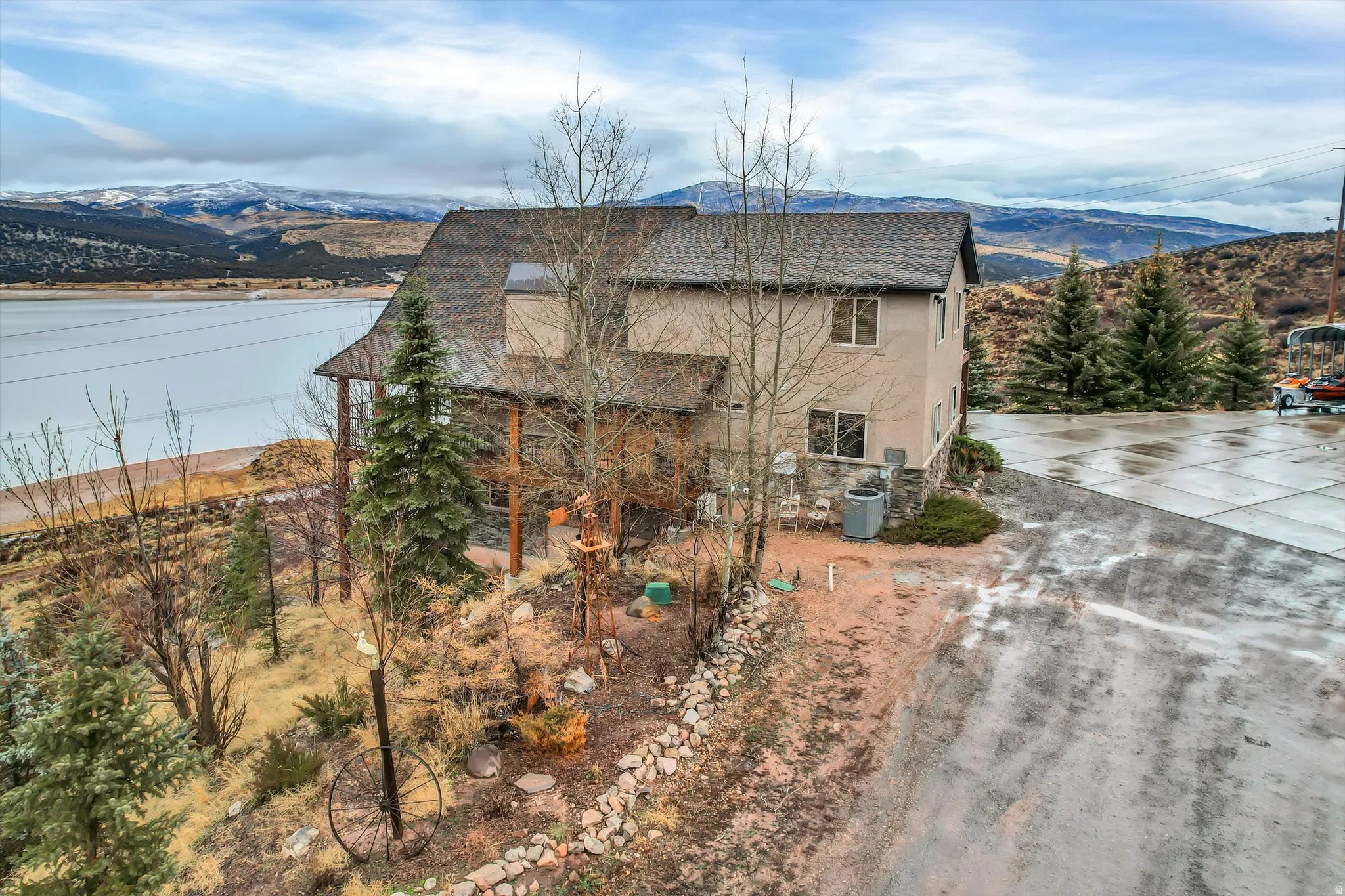 View of side of home featuring a mountain view, stucco siding, and a shingled roof