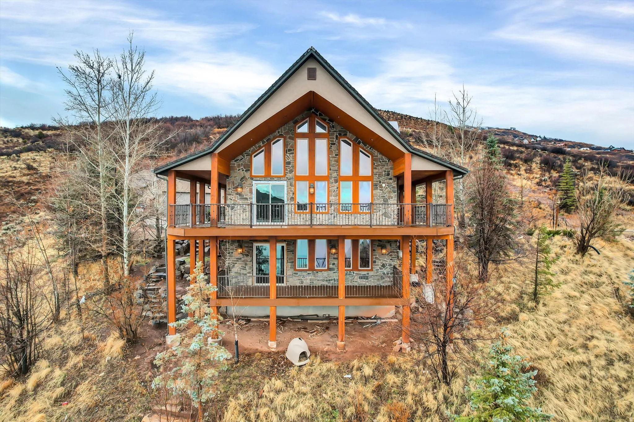 Back of property featuring stone siding