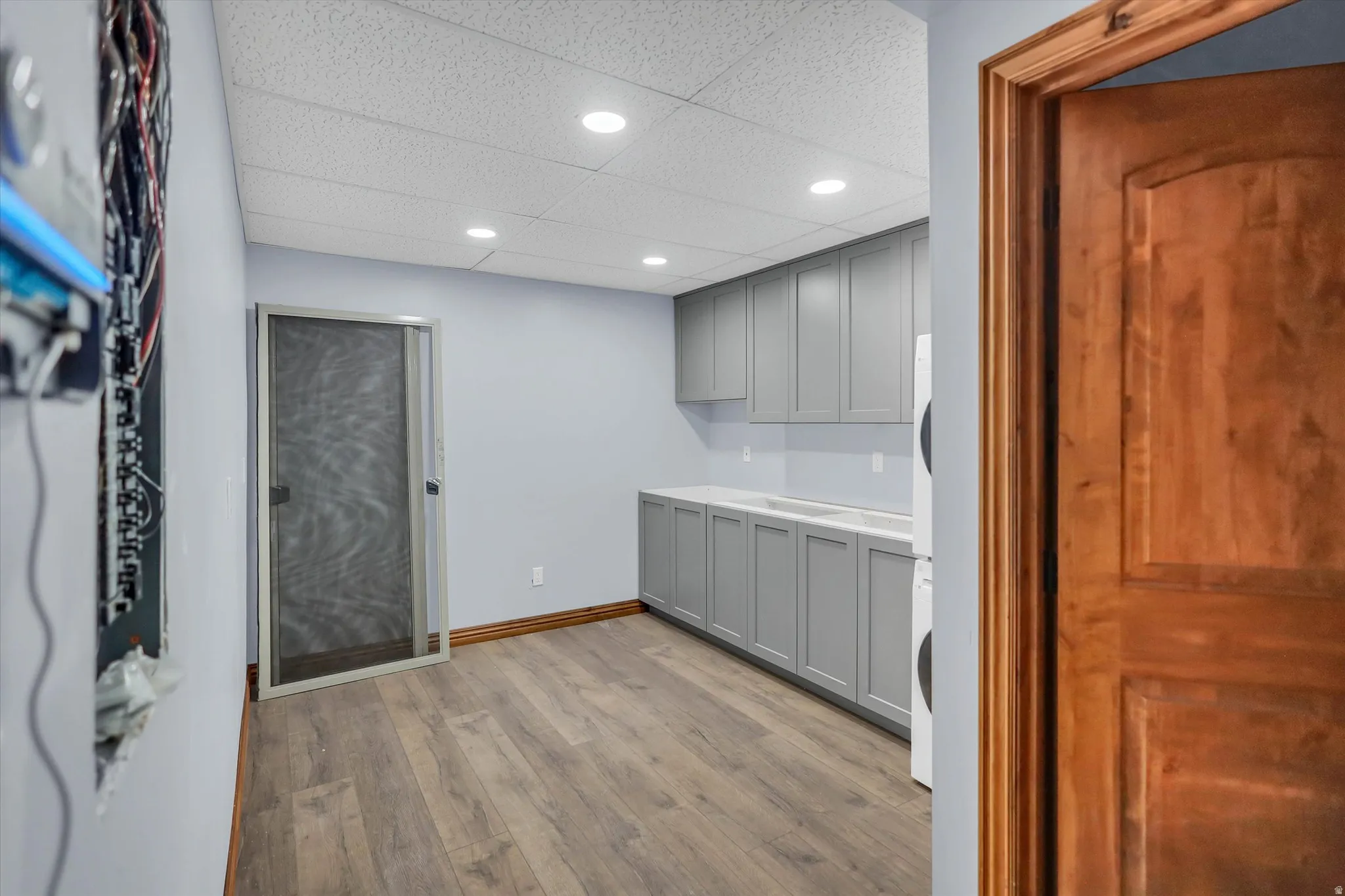 Bar with gray cabinets, light countertops, a paneled ceiling, light wood-style flooring, and recessed lighting
