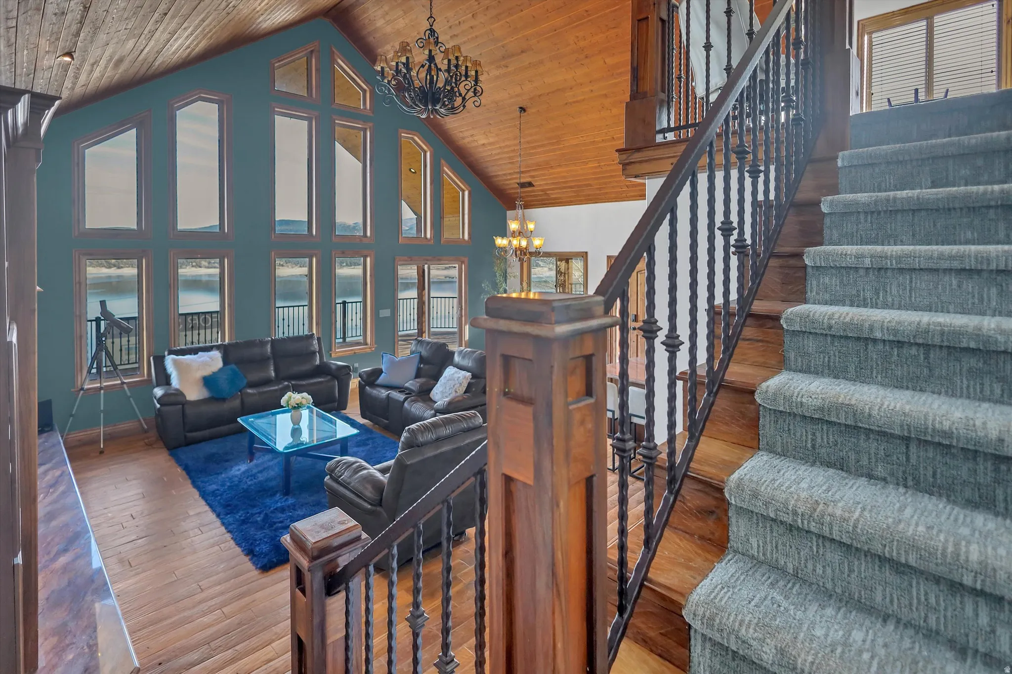 Living room with a chandelier, hardwood / wood-style flooring, and a high wood ceiling