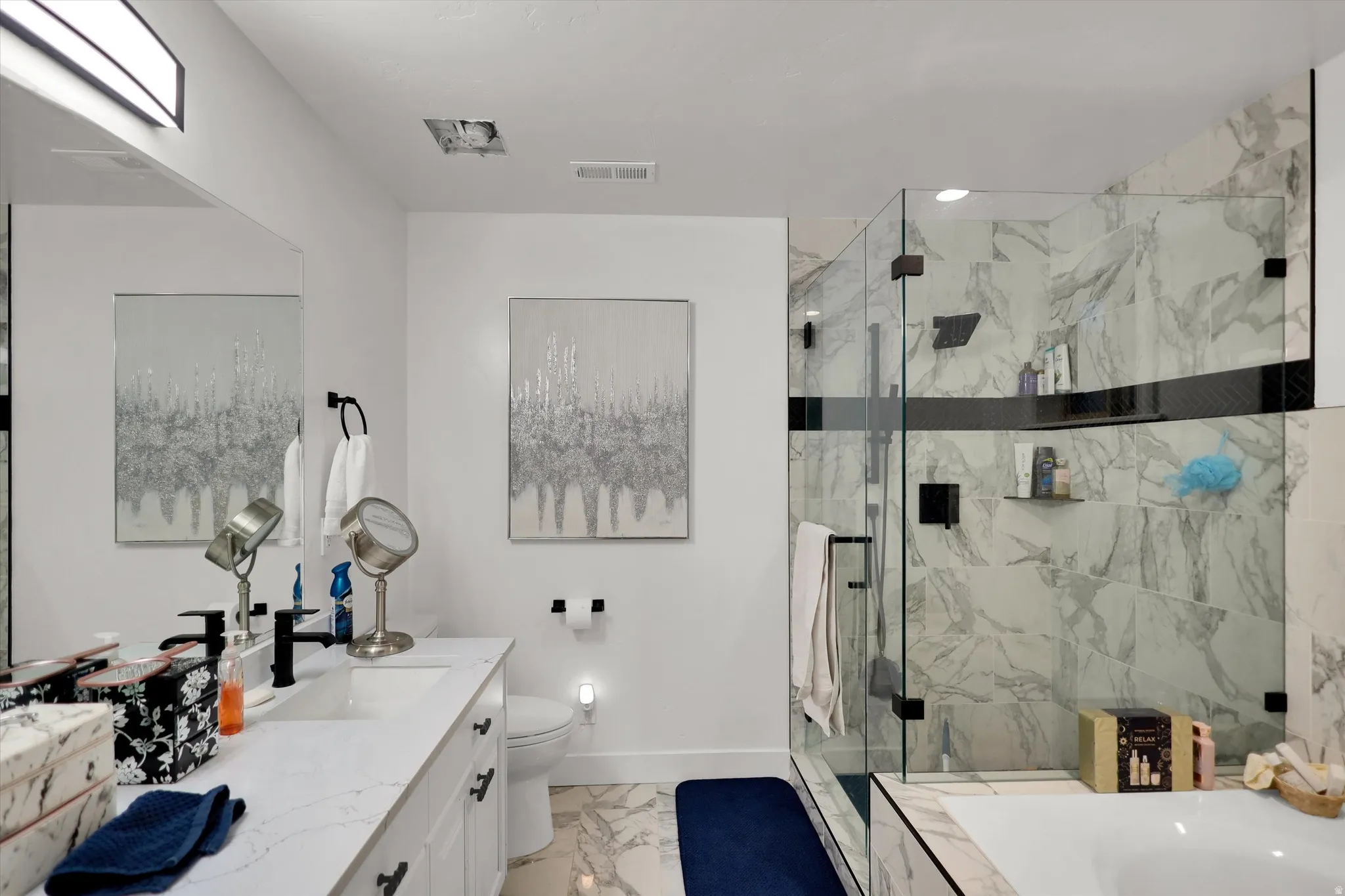 Bathroom featuring light marble finish floors, vanity, a marble finish shower, and a bathtub