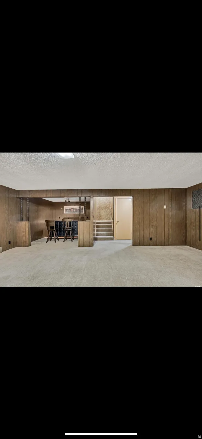 Interior space featuring wooden walls, a textured ceiling, and stairway