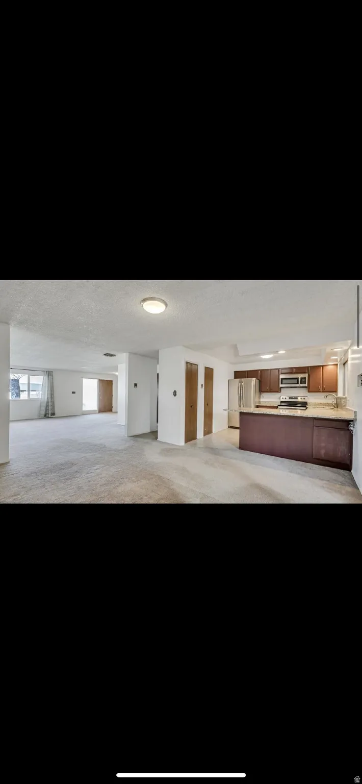 Misc room featuring a textured ceiling and carpet flooring