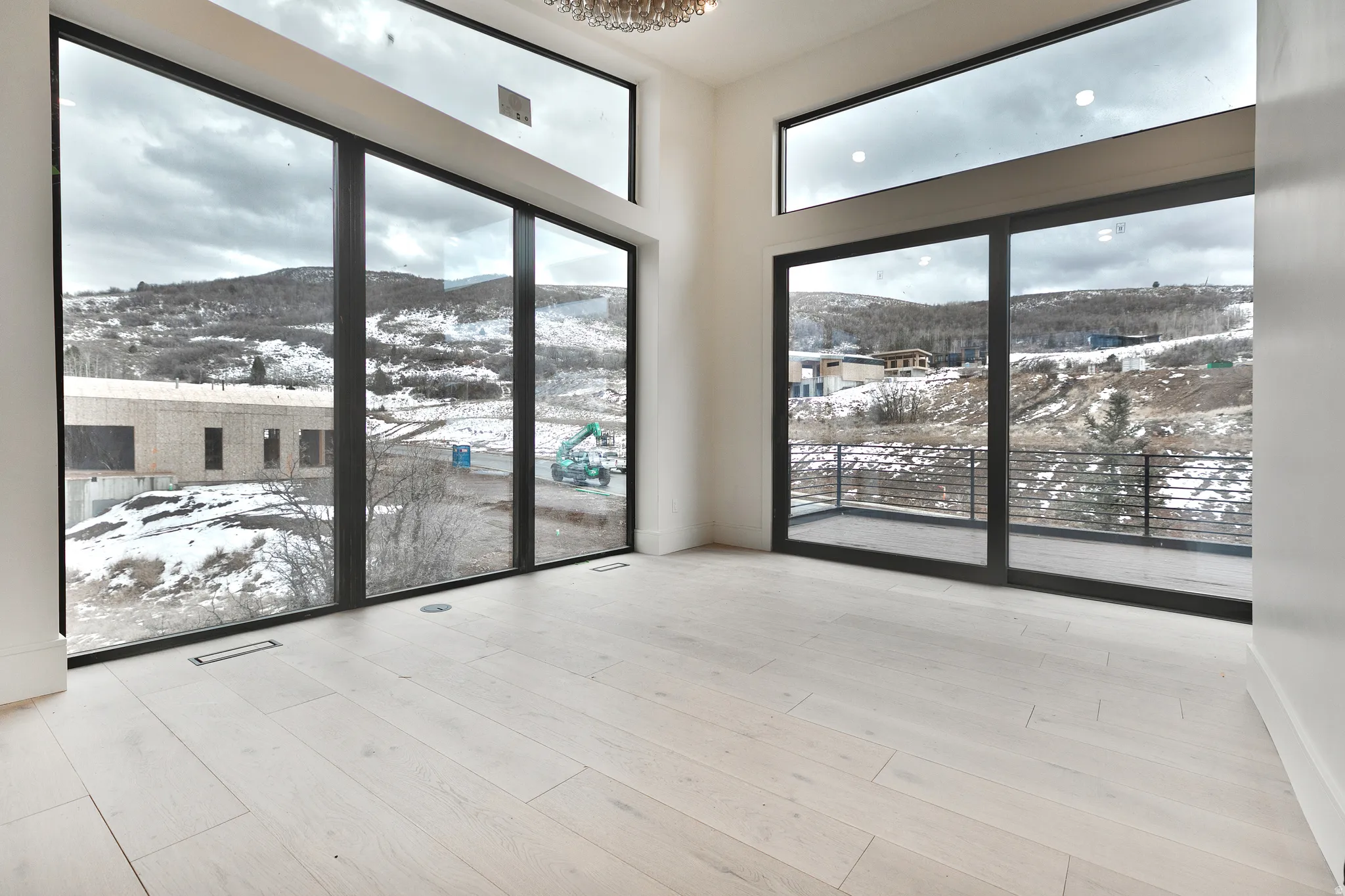 Primary suite featuring vaulted ceilings, expansive windows, light wood finished floors