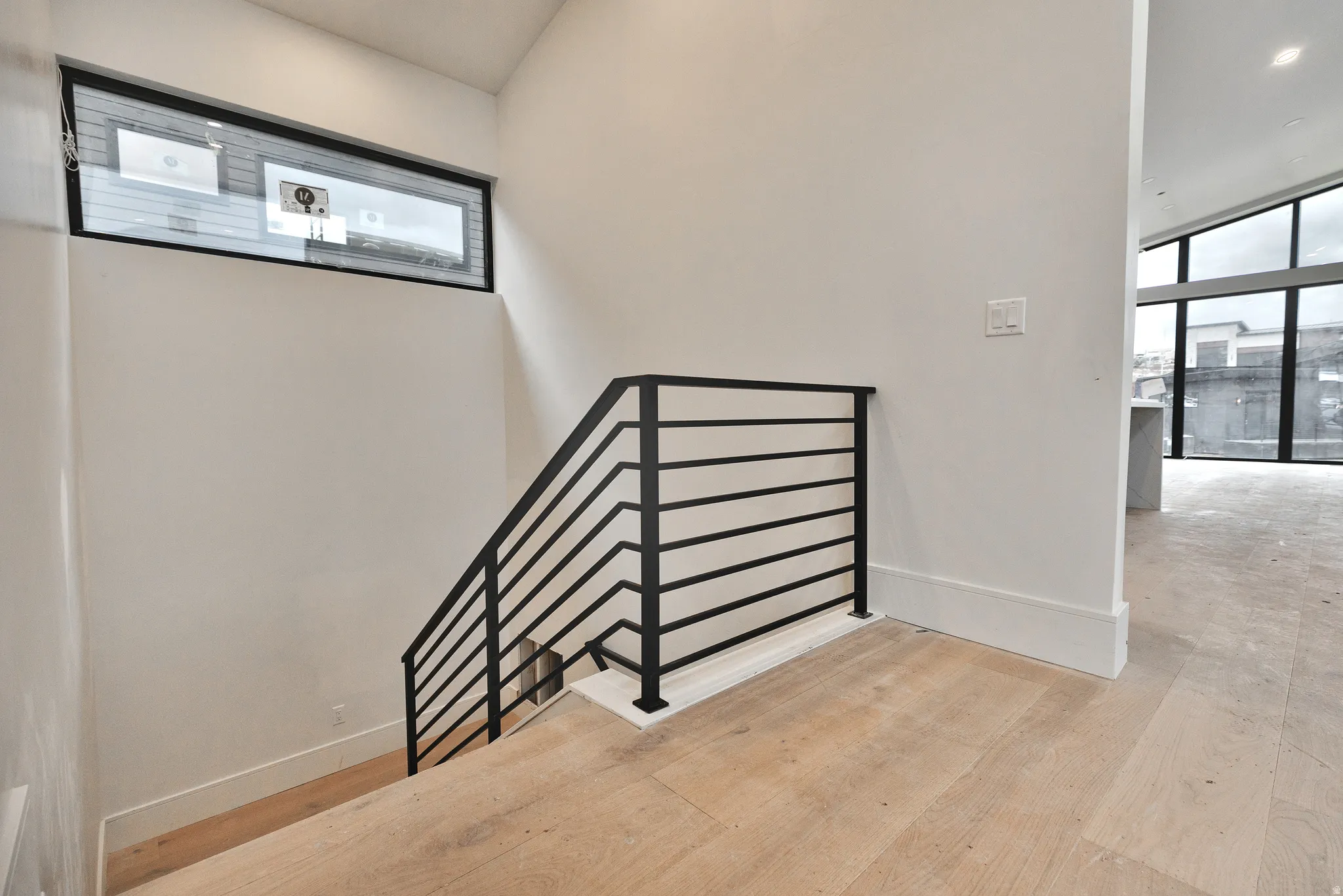 Staircase with hardwood / wood-style flooring and floor to ceiling windows.