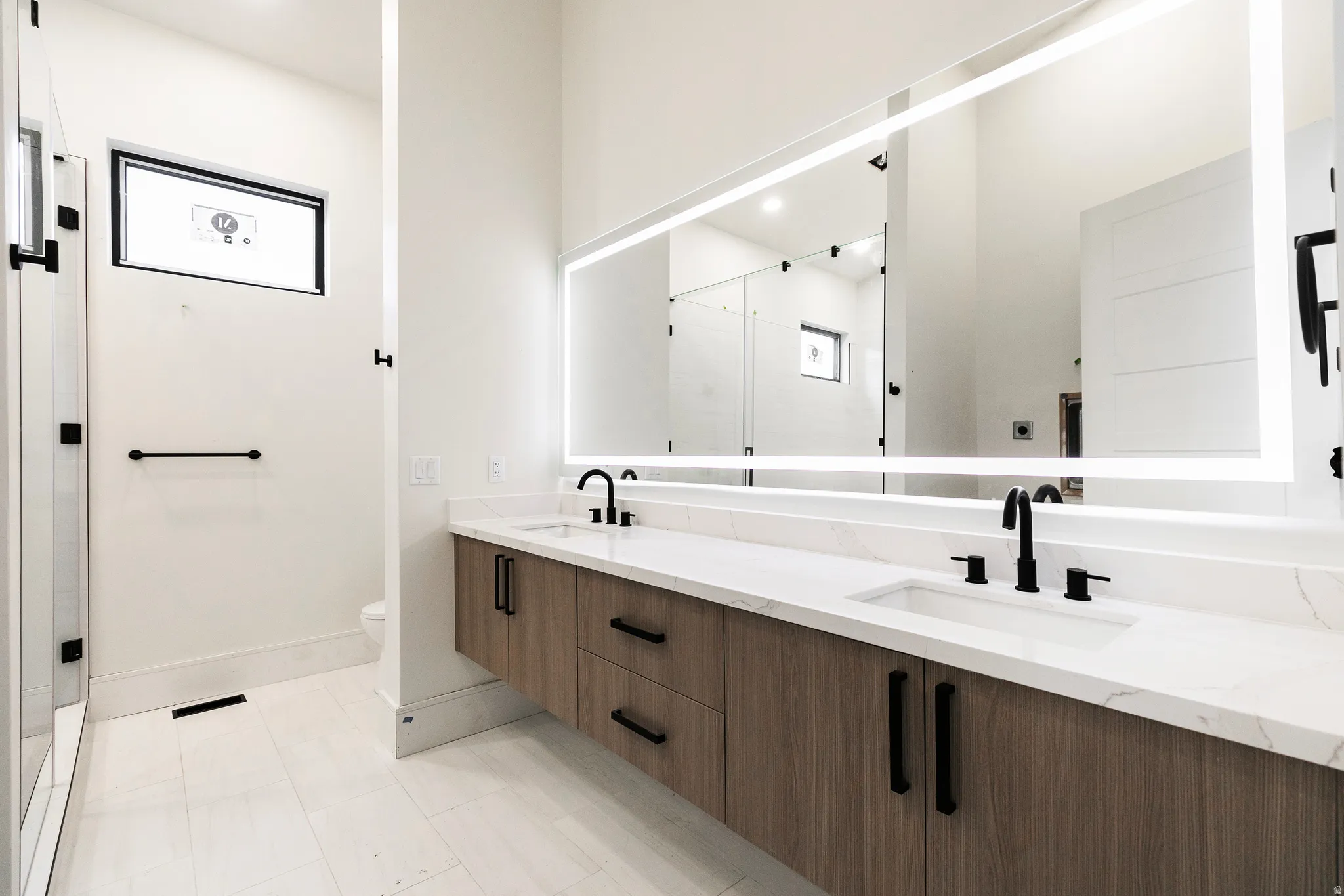 Bathroom with double vanity, and lighted mirror