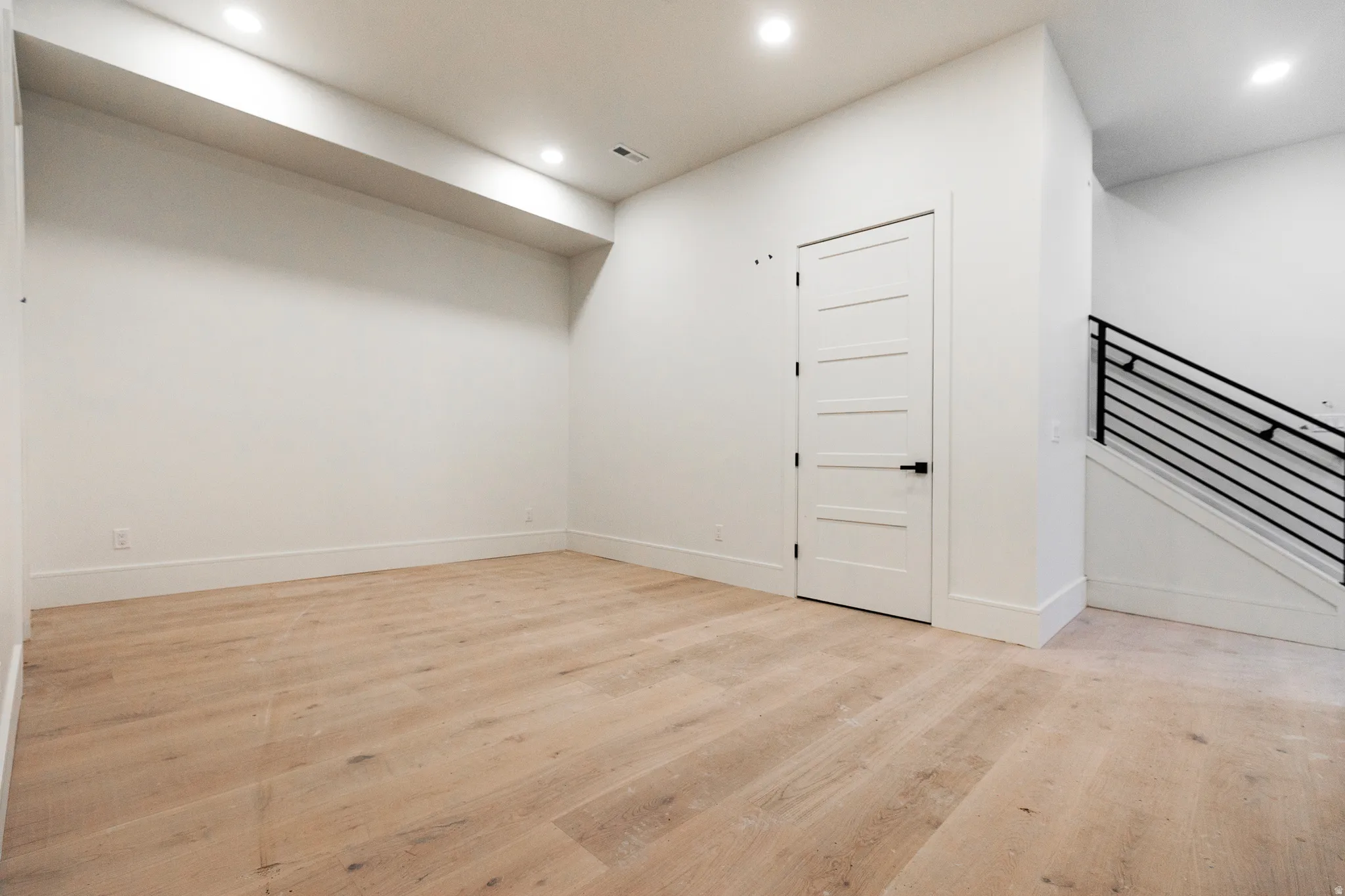 Basement flex/family room featuring light wood-type flooring, recessed lighting, and stairs