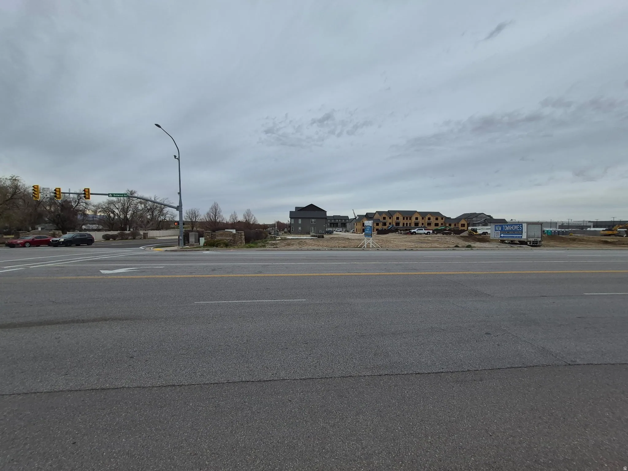 View of asphalt road with traffic lights and street lighting