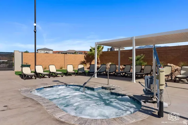 View of pool with a hot tub, a patio, a fenced backyard, and a swimming pool