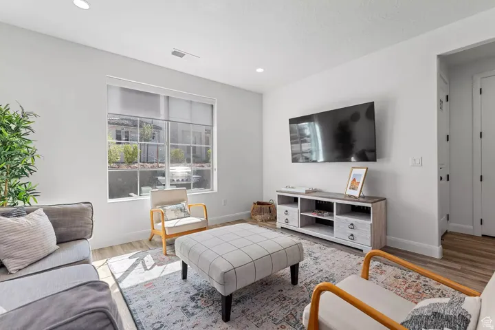 Living area with wood finished floors and recessed lighting