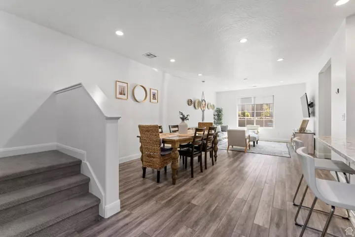 Dining room featuring stairs, recessed lighting, wood finished floors, and a textured ceiling