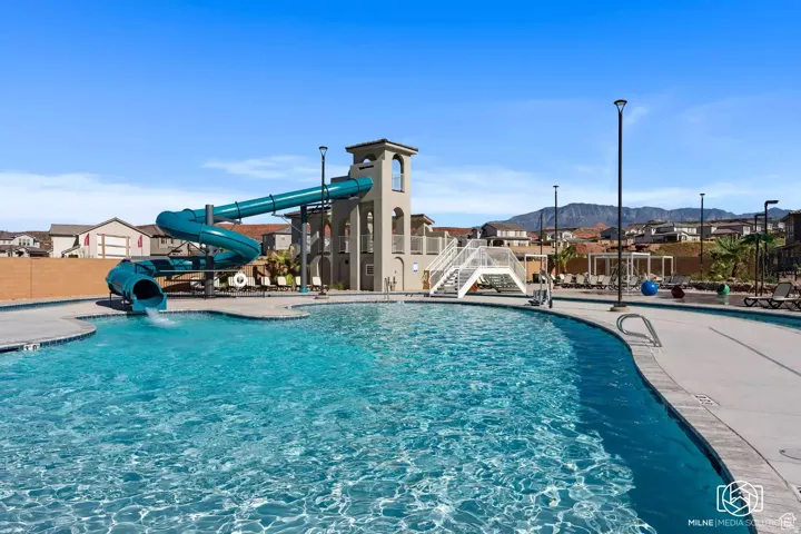 Community pool with a water slide and a mountain view