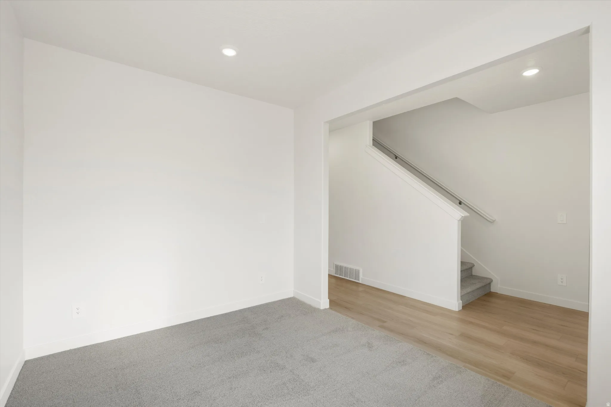 **DISCLAIMER** Interior colors & finishes may vary.Basement with stairway, recessed lighting, carpet floors, and wood finished floors