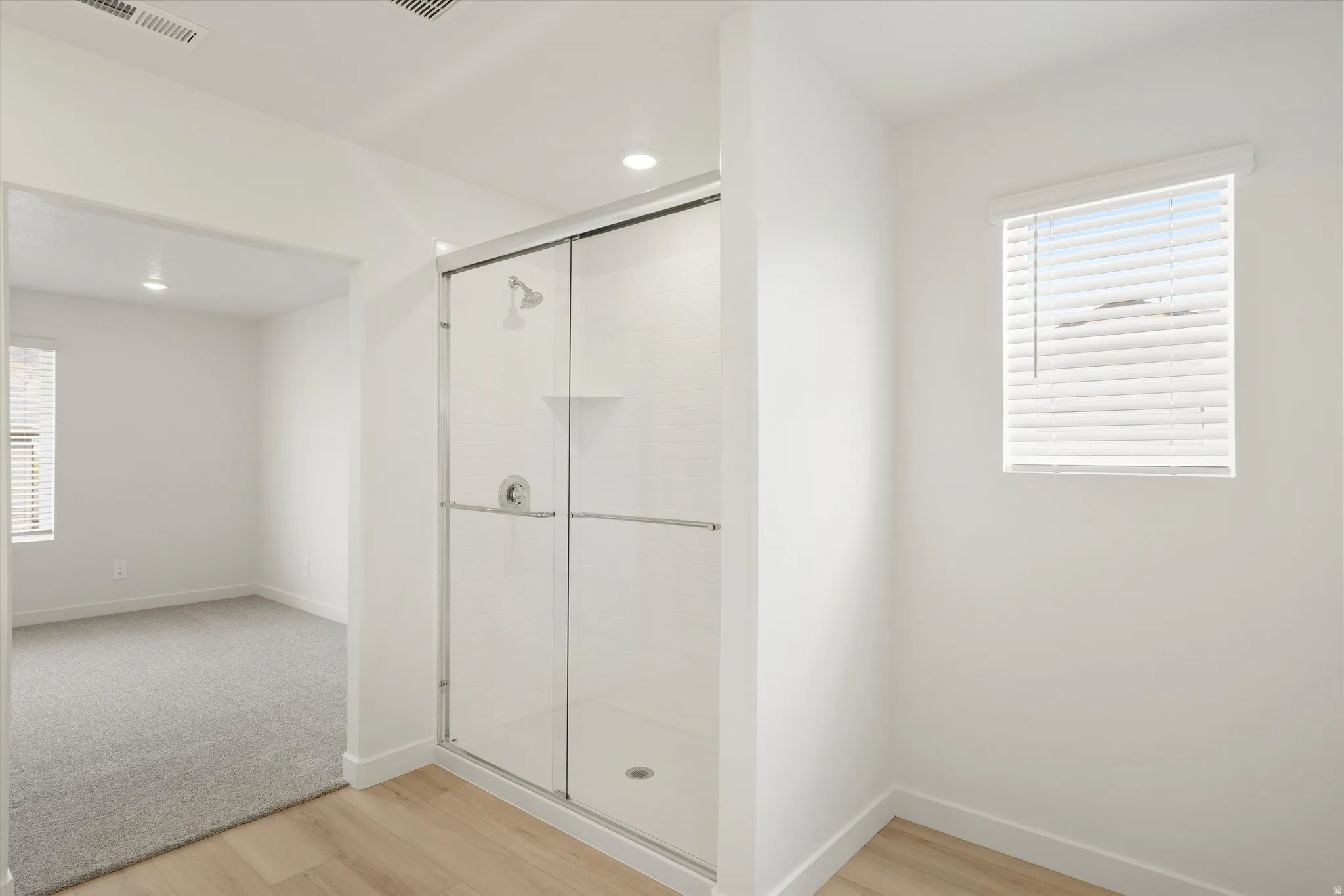 **DISCLAIMER** Interior colors & finishes may vary.Bathroom featuring light wood-type flooring, a stall shower, and recessed lighting