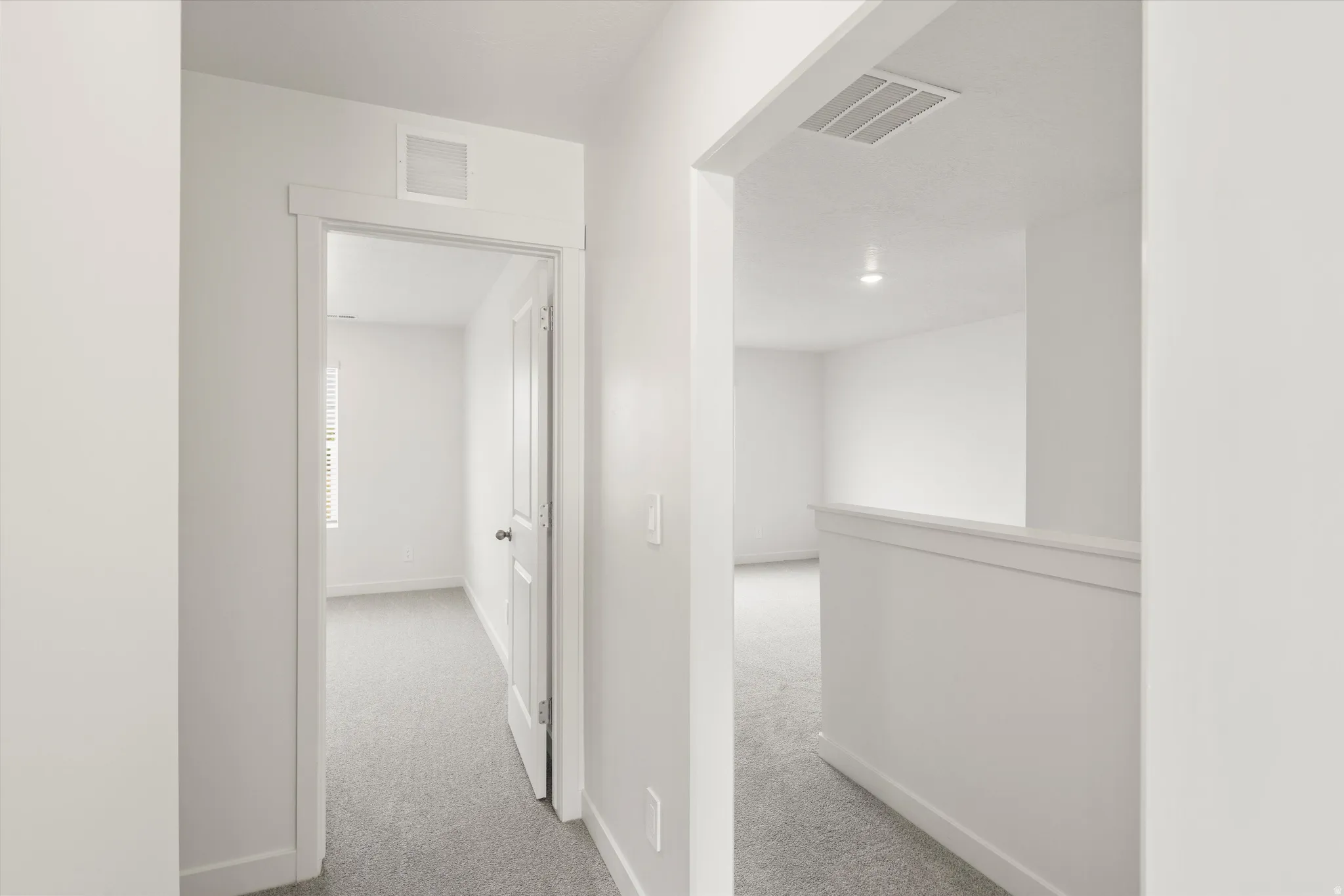 **DISCLAIMER** Interior colors & finishes may vary.Hallway with light colored carpet and baseboards