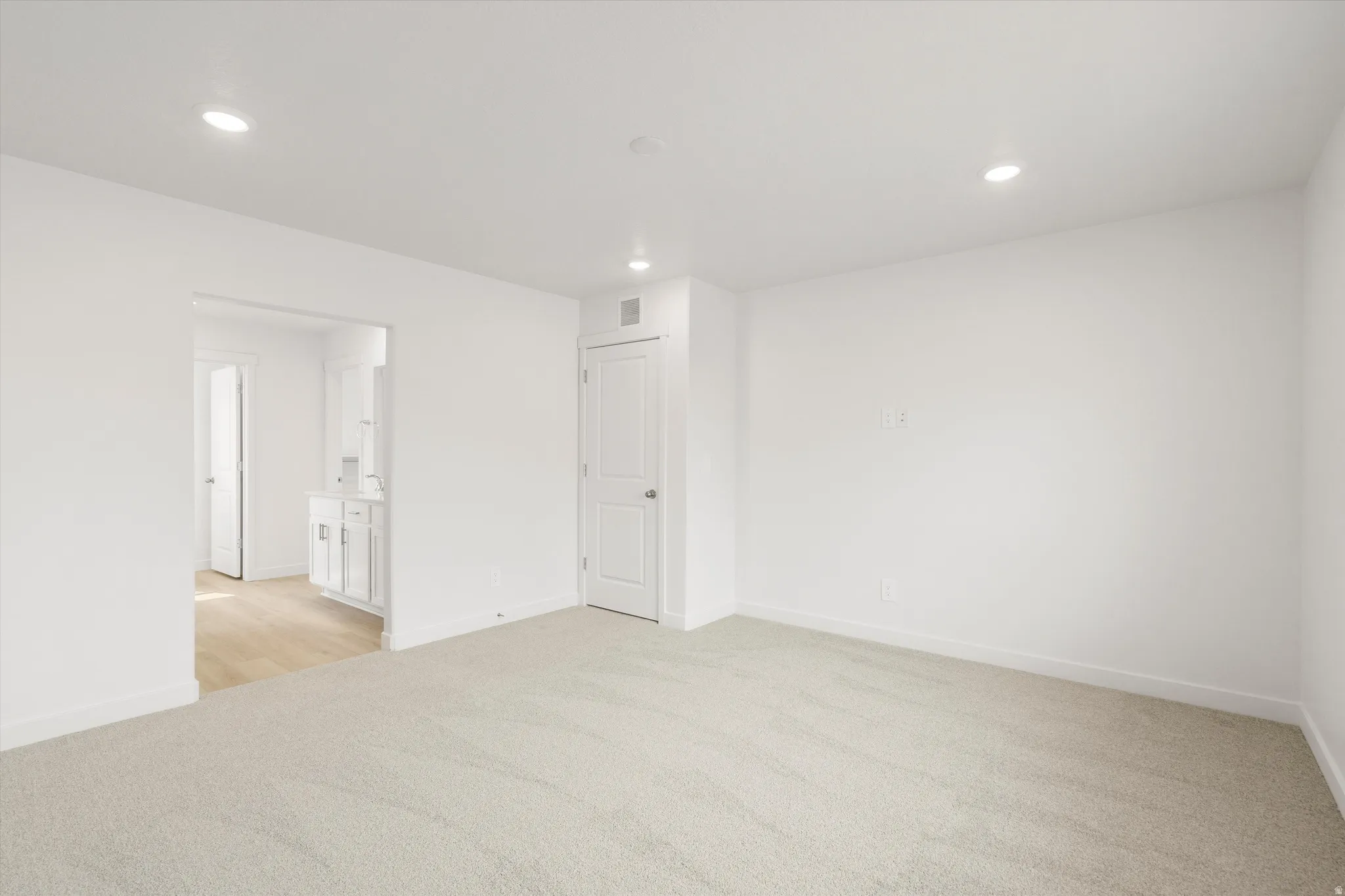 **DISCLAIMER** Interior colors & finishes may vary.Spare room with light carpet and recessed lighting