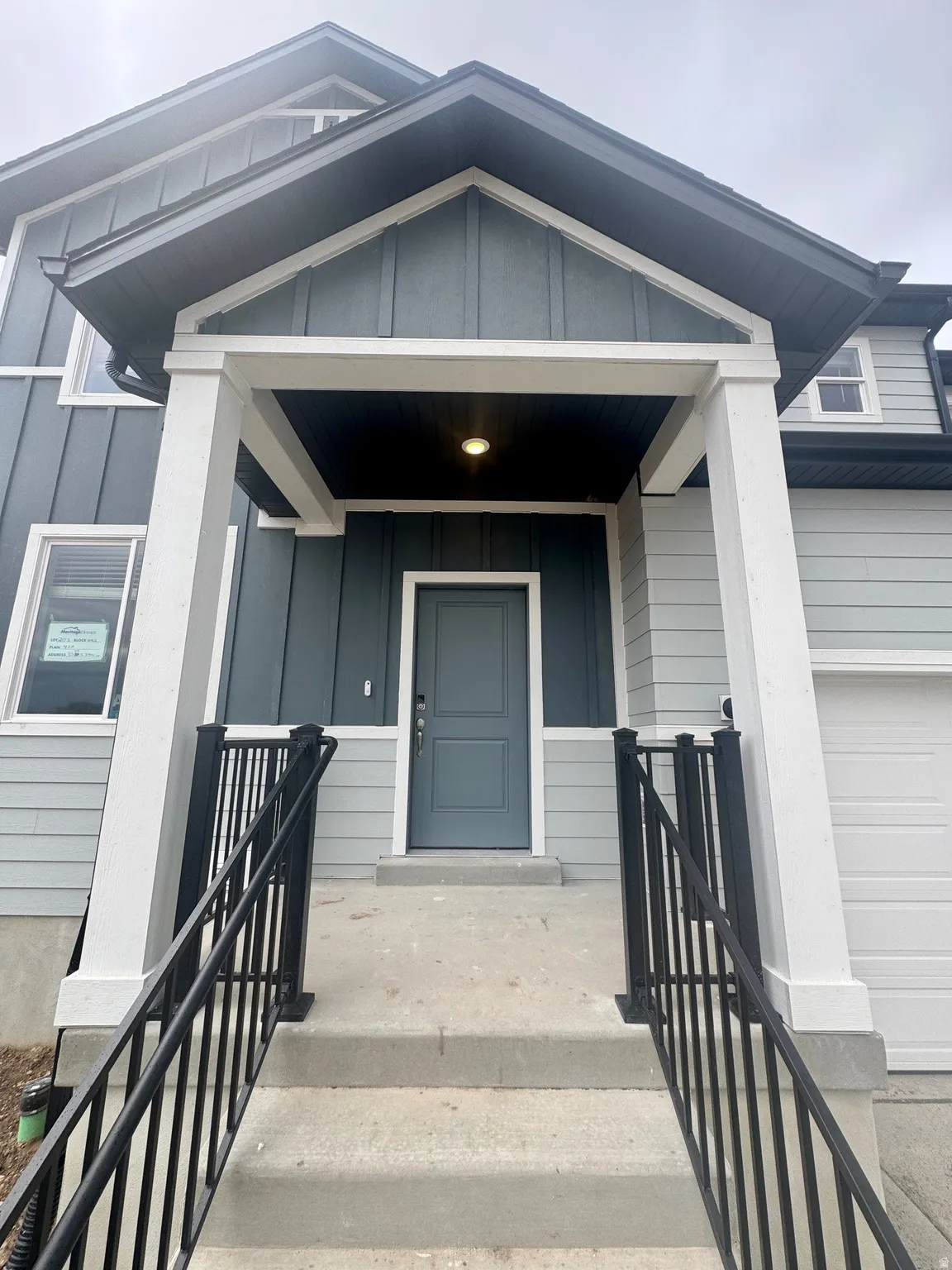 Doorway to property with covered porch and board and batten siding