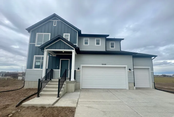 View of front facade featuring concrete driveway, board and batten siding, and an attached garage