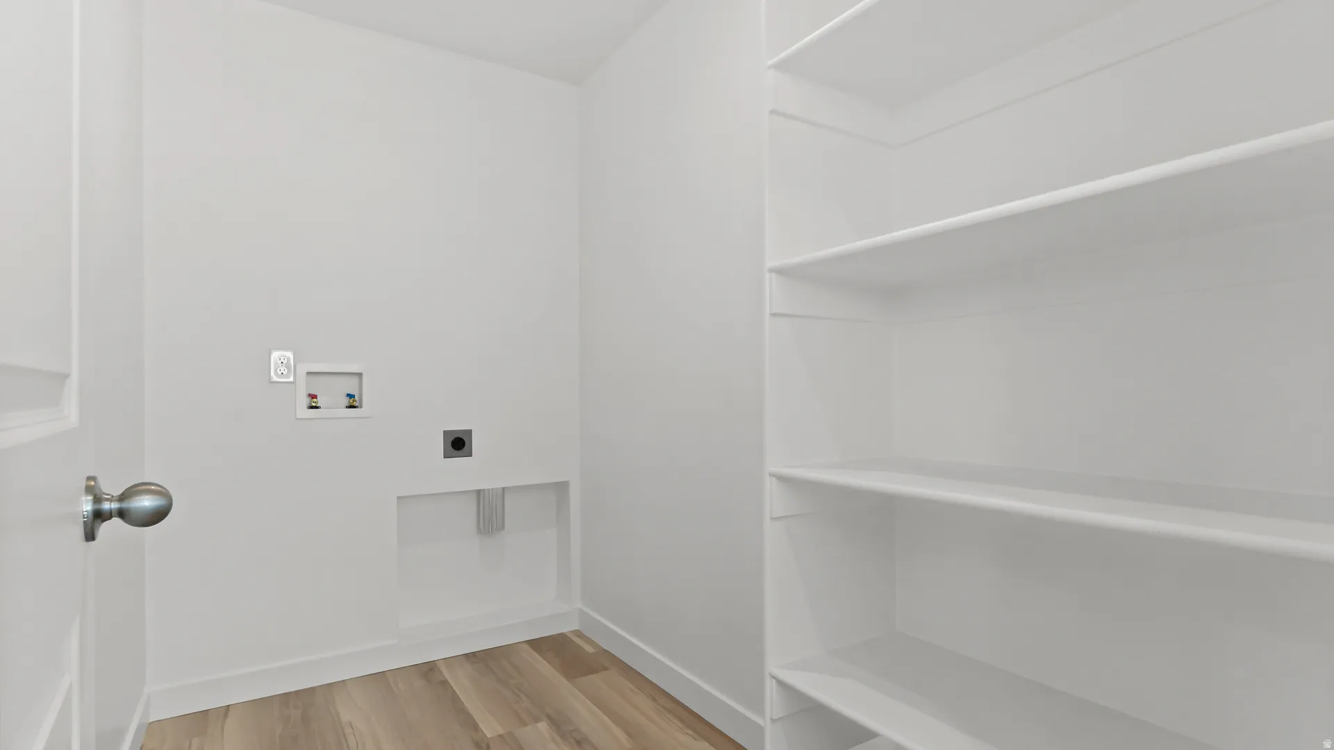 Dedicated utility space featuring laundry hookups and integrated shelving