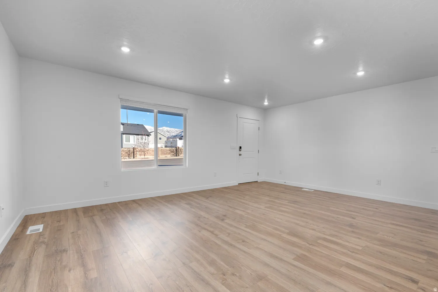 Unfurnished room with light wood finished floors and recessed lighting