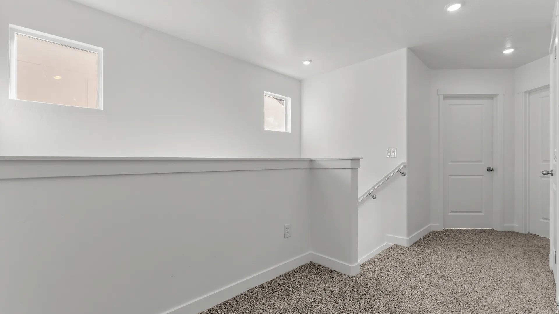Carpeted hallway featuring white walls, recessed lighting, and white trim