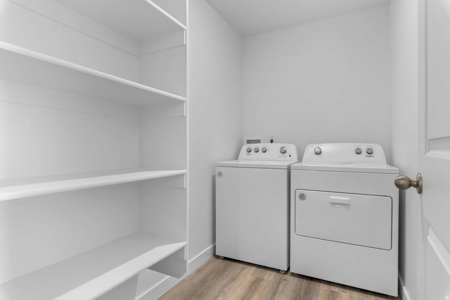 Washroom with light wood finished floors and separate washer and dryer
