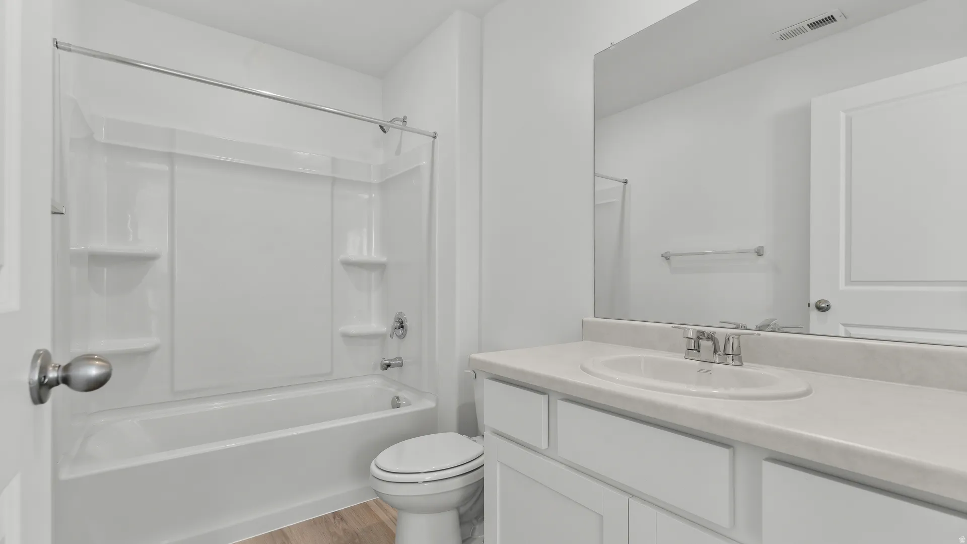 Bathroom featuring a white vanity with an integrated sink, polished chrome faucet, and a large wall-mounted mirror
