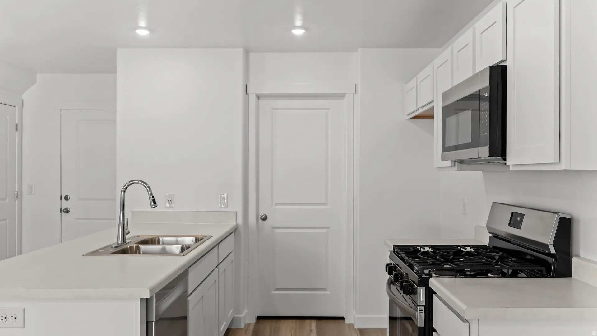 Contemporary kitchen featuring white cabinetry and light countertops