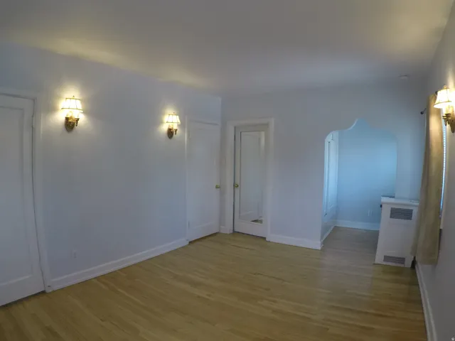Apt # 15 > Spare room with light wood finished floors and arched walkways