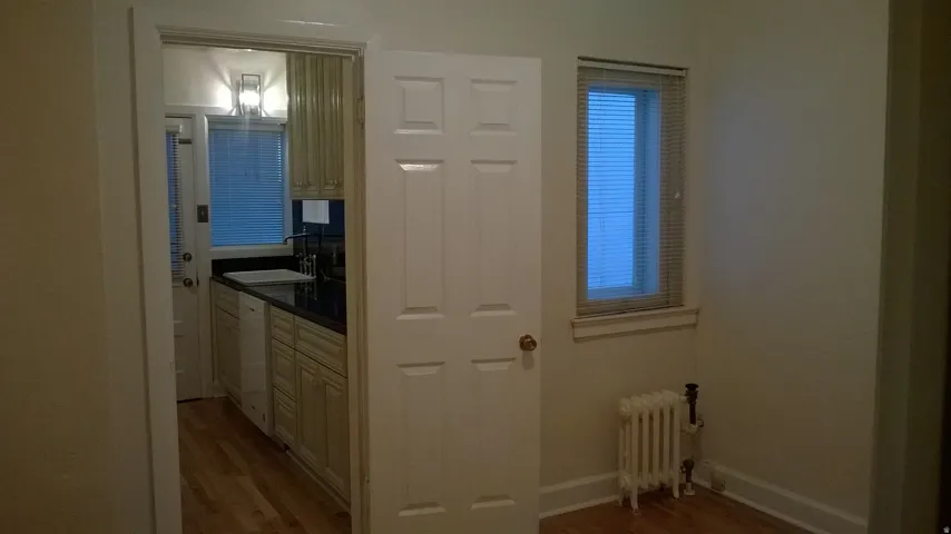Apt # 1 Hall with radiator heating unit and light wood finished floors
