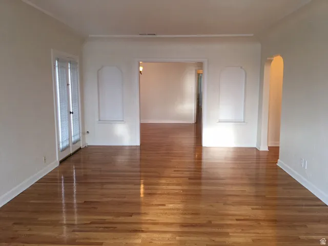 Apt # 7 > Spare room with arched walkways and wood finished floors