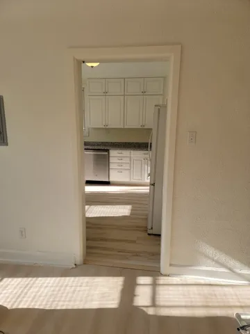 Apt # 9 > Hallway with a textured wall and light wood-style floors