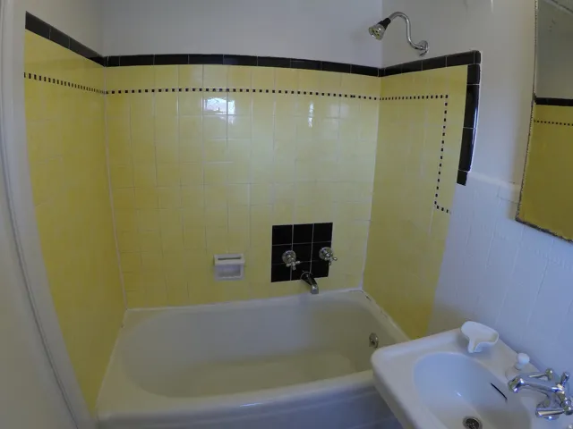 Apt # 8 > Bathroom featuring tile walls and washtub / shower combination
