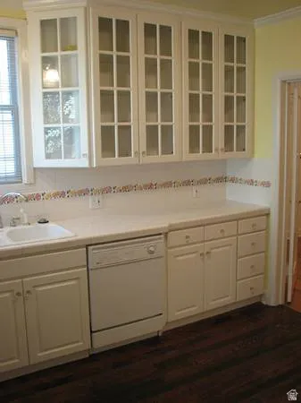 Apt # 11 > Kitchen featuring white cabinets, light countertops, dishwasher, glass insert cabinets, and dark wood-type flooring