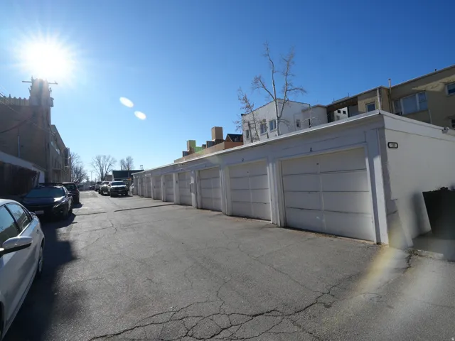 View of asphalt road featuring community garages