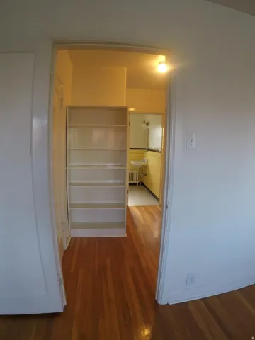 Apt # 4 >  Hallway featuring dark wood-type flooring and radiator heating unit
