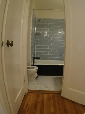 Apt # 4 > Bathroom with light wood-type flooring and bathing tub / shower combination