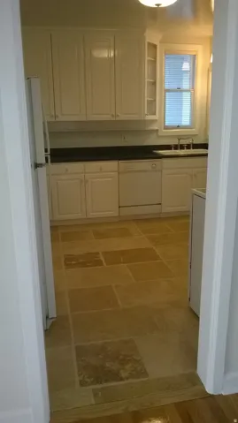 Apt # 10 > Kitchen featuring white cabinetry, dark countertops, white appliances, and glass insert cabinets