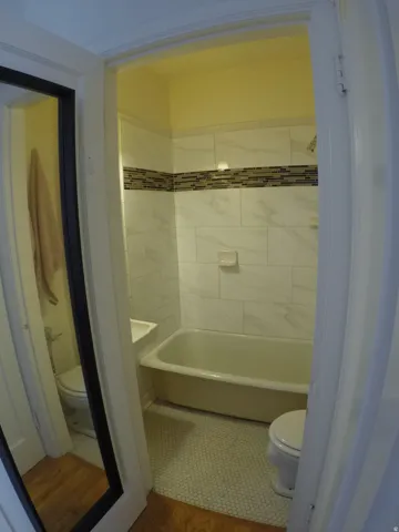 Apt # 7 > Full bathroom featuring toilet and wood finished floors