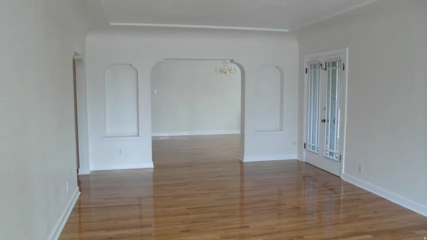 Apt # 10 > Spare room featuring a chandelier and light wood-style floors