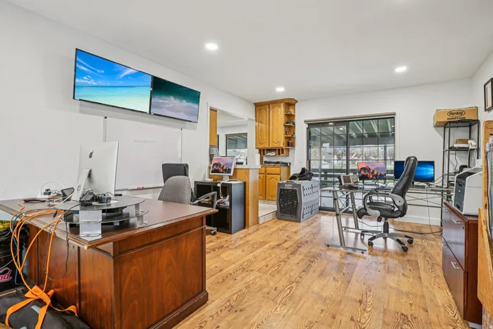 Office with light wood finished floors and recessed lighting