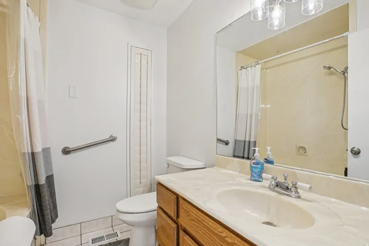 Full bath with vanity and light tile patterned floors